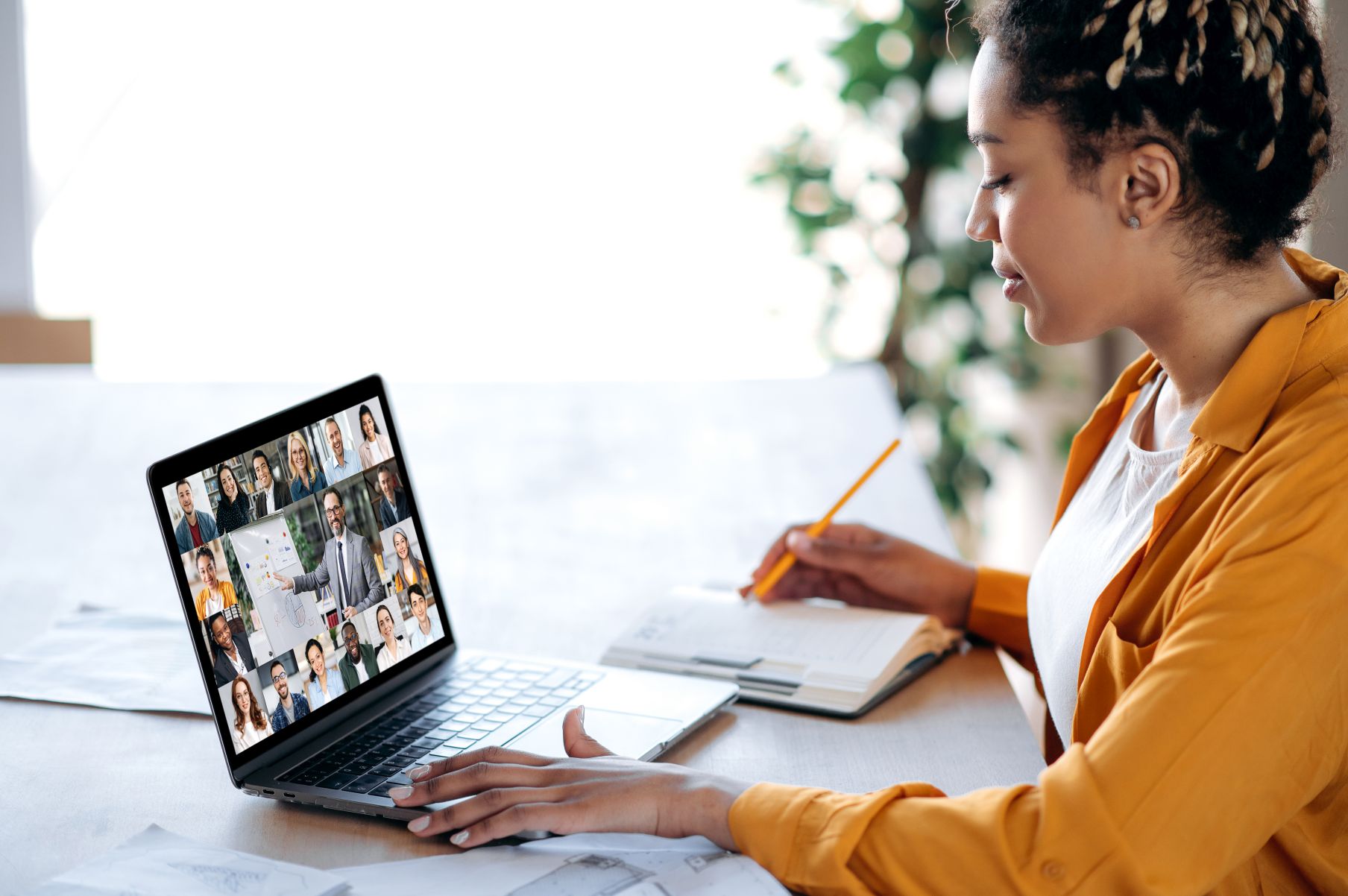 Inline briefing, conference. African American female manager communicates with business team during video call, listens financial webinar, takes notes, on laptop screen tutor and multiracial people