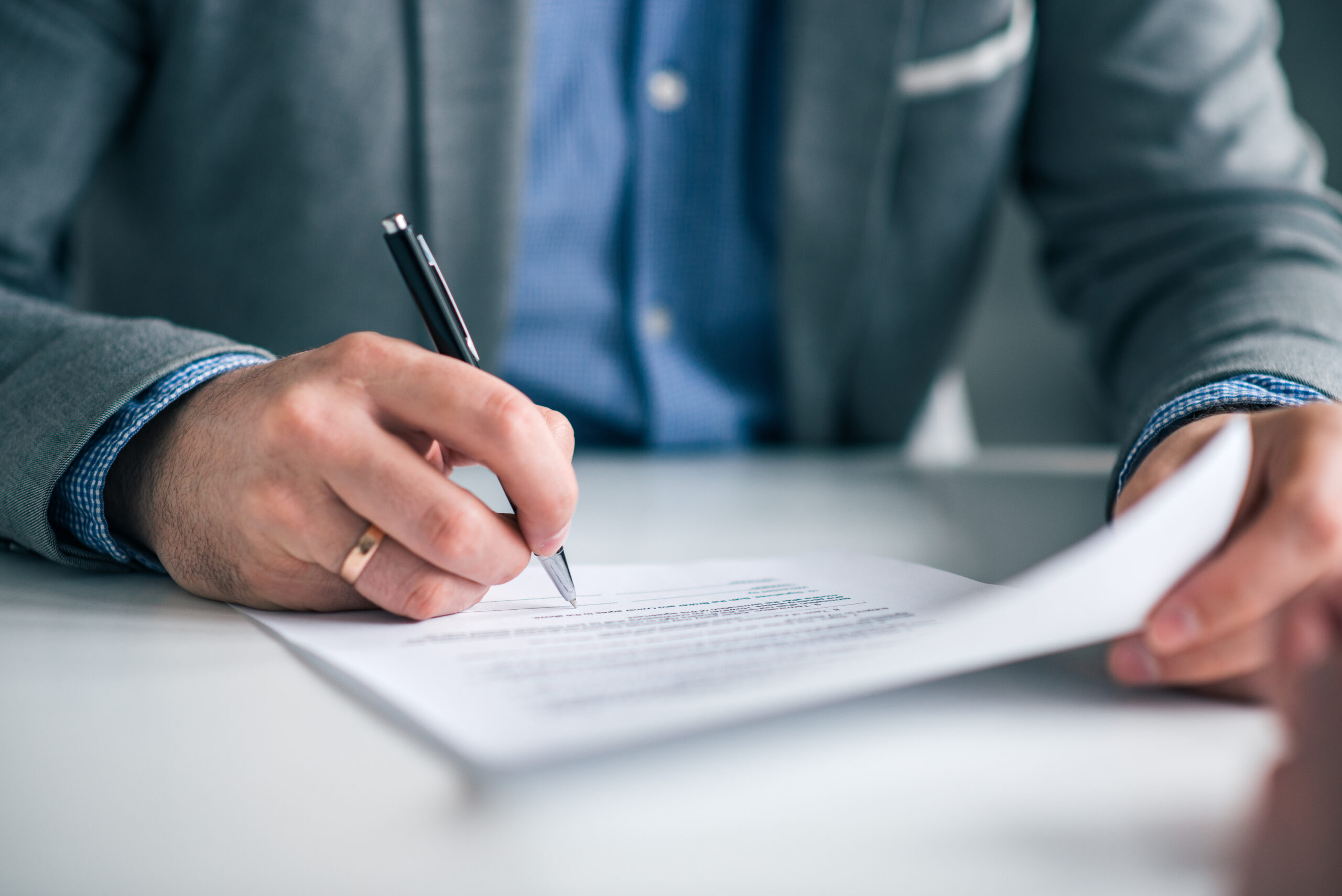 Businessman hand signing contract, close-up.